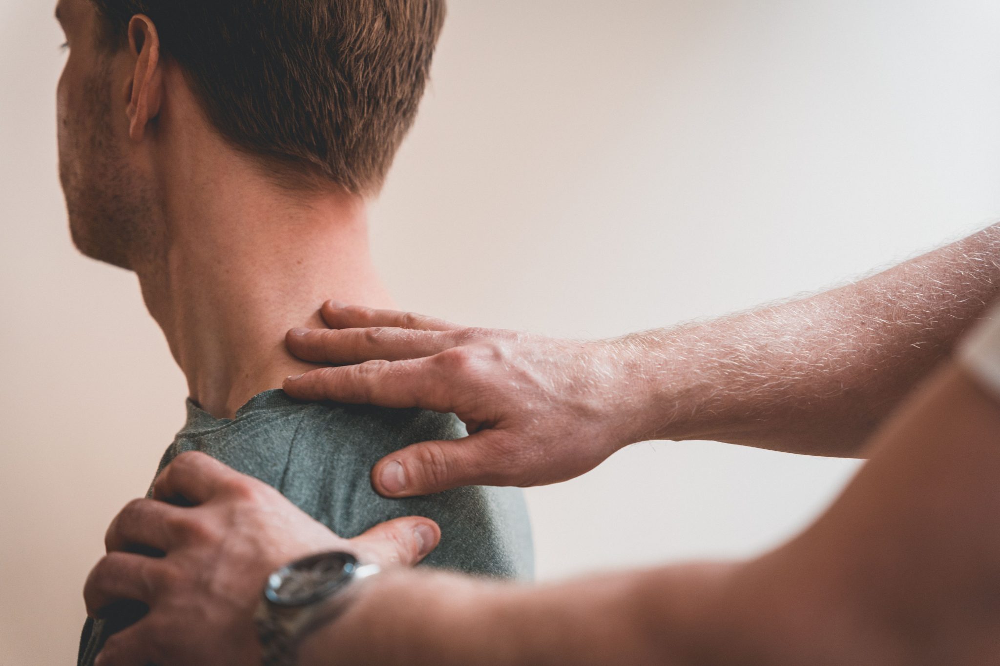 Man having upper spine adjusted at the chiropractor